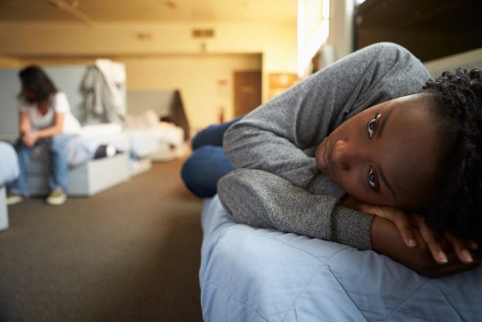 A child rests on a mattress at a homeless shelter.
