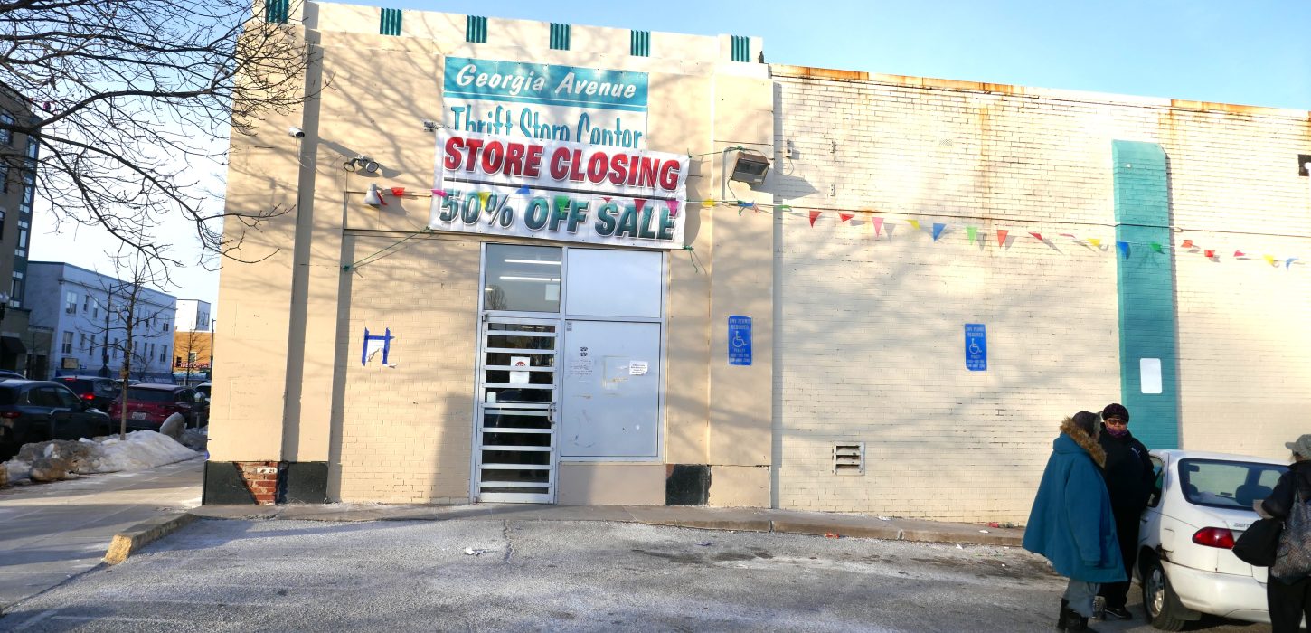 Photo of a the outside of the thrift store with a large banner reading, "Store Closing."