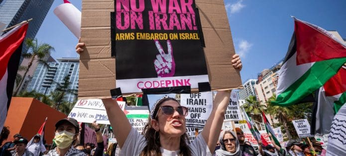 A demonstrator in Los Angeles holds a sign reading "No War on Iran" (Shutterstock)